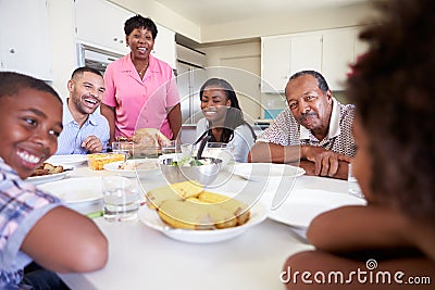 Multi-Generation Family Sitting Around Table Eating Meal