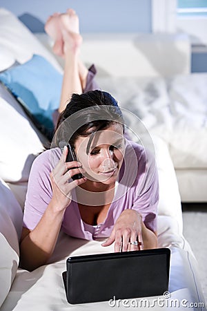 Multitasking woman talking on phone using laptop