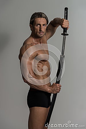 Muscled Male Model In Studio With A Sword