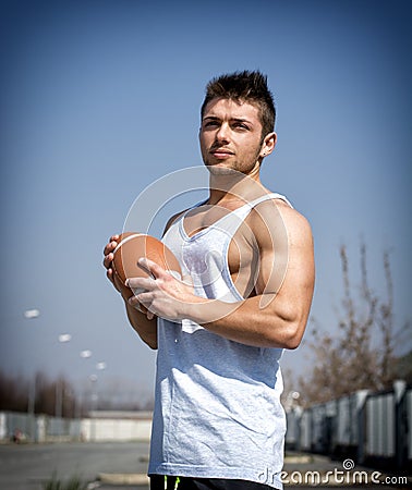 Muscular american football with ball in hand.