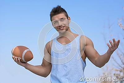 Muscular american football player with ball in hand, arms open