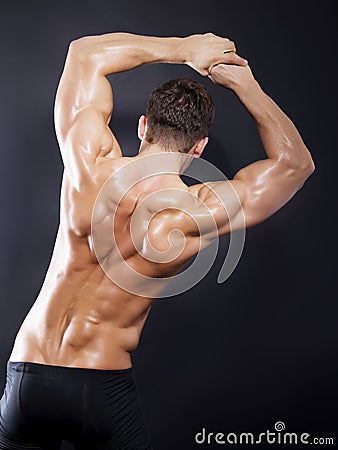Muscular male back on black background