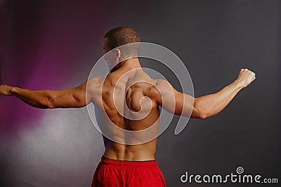 Muscular male back in red shorts