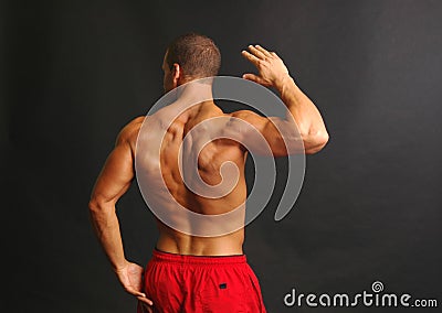 Muscular male back in red shorts