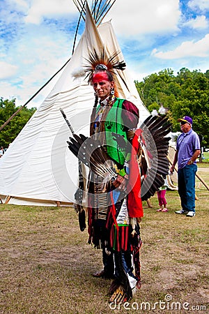Native American Indian warrior in front of Tipi