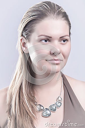 Natural blond woman with necklace looking away