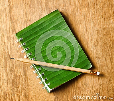 Notepad with cover of leaf lies on wooden board