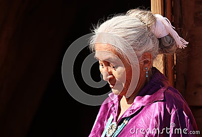 A Navajo Woman Looking Down Outdoors in Bright Sun