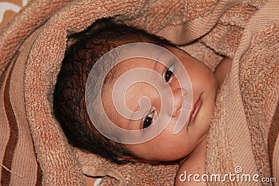 New born asian baby girl wrapped in a towel