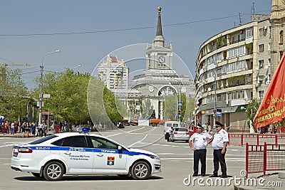 New police car and the police are standing in the cordon at the victory parade near the Central train station Volgograd-1