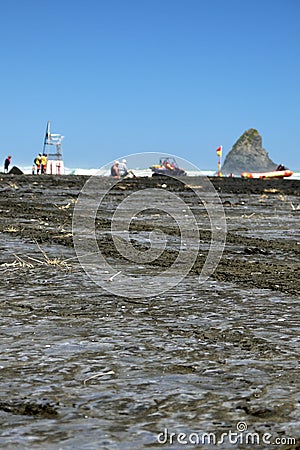 New Zealand: surf life-savers on black sand beach