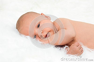 Newborn cute baby boy lying on fur blanket