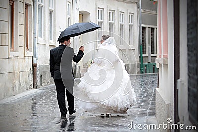 Newlywed couple in rain