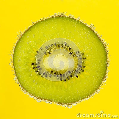 Nice slice of kiwi, covered with bubbles on yellow
