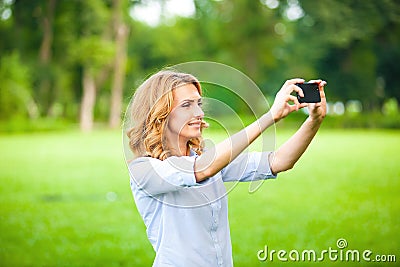 Nice woman taking pictures with smartphone