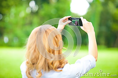 Nice woman taking pictures with smartphone