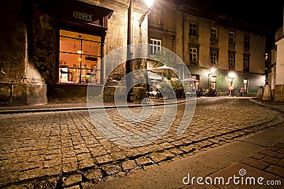 Night street of old city with cobble stone road and bars