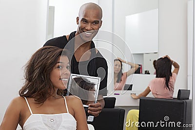 拿着在少妇后的<em>美发师</em>一个<em>镜子</em> 免版税库存图