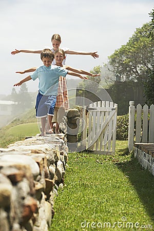 平衡的<em>兄弟姐妹</em>,当<em>连续</em>走在石墙上时 图库摄影