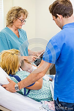 Nurse Explaining Reports On Tablet To Couple With