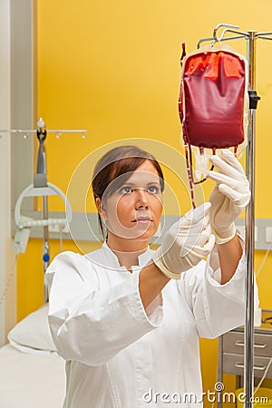 Nurse in hospital with blood bottle.