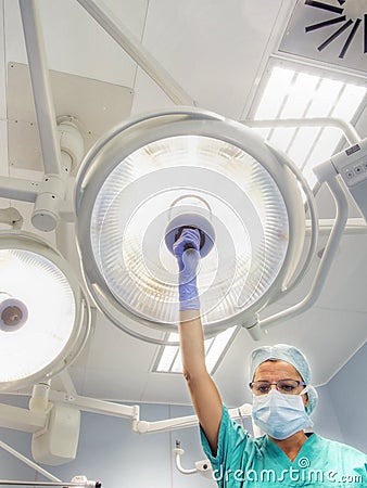 Nurse places surgical lamp on the operating table