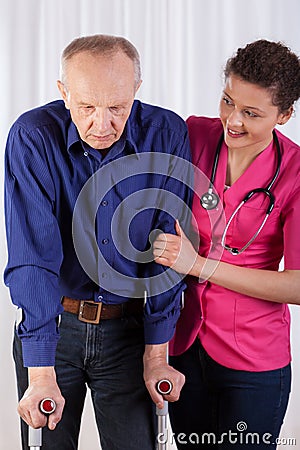 Nurse protecting man on crutches