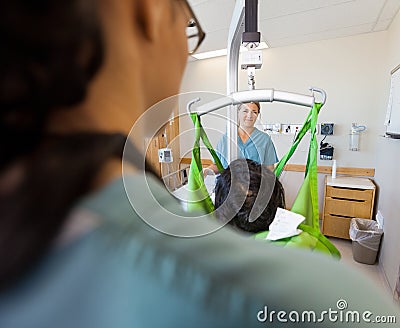 Nurse Smiling With Patient On Hydraulic Lift