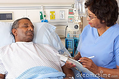 Nurse Talking To Senior Male Patient On Ward