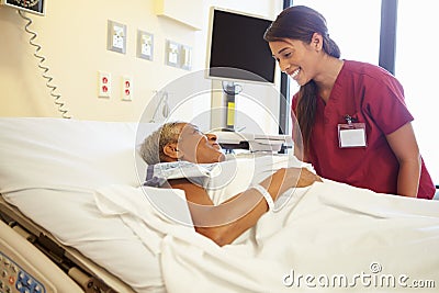 Nurse Talking To Senior Woman In Hospital Room