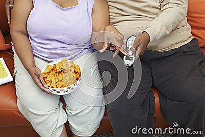 Obese Couple Sitting On Couch