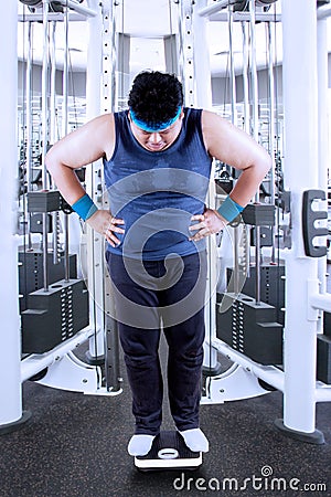 Obesity man measure his weight