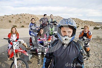 Off Road Motor Biker Standing With Friends In The Background