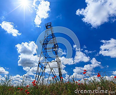 Oil and gas rig profiled on blue sky with clouds