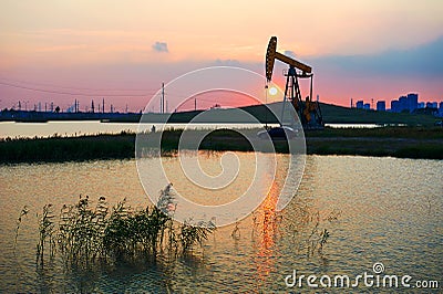 Oil pumping machine sunset lakeside