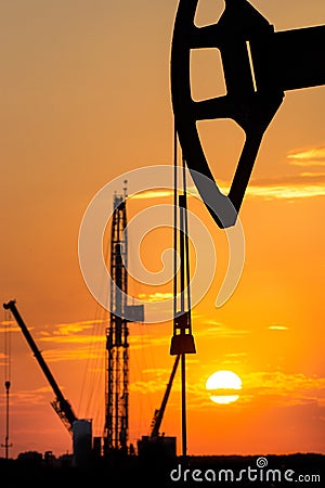 Oil rig over orange sky