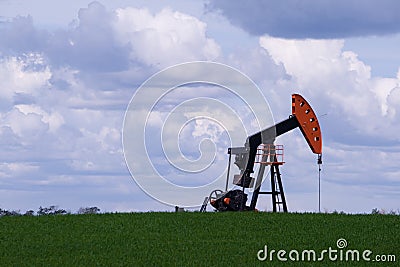 Oil well pump jack in green field