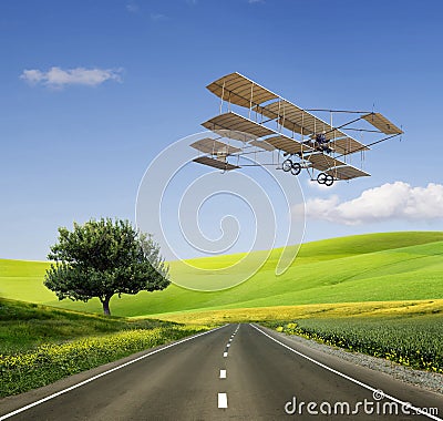 Old aircraft on the green field and road