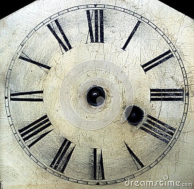 Old antique clock face with hands removed close-up detail.