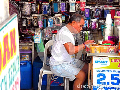 Old asian man working in cellphone repair shop