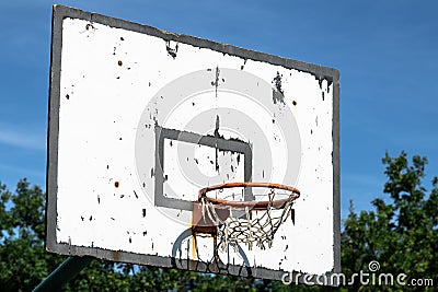 Old basketball hoop under a blue sky