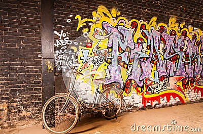 Old bicycle is leaning on art graffiti wall,798 street, Beijing on 25 May 2013