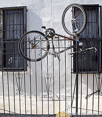 Old bicycle locked to metal gate in Brooklyn