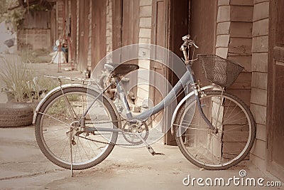 Old bike in front of the wooden wall at home