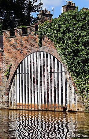 An old boat shed on a canal. Castle design, large wooden doors and 