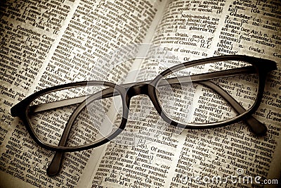 Old dictionary and black glasses