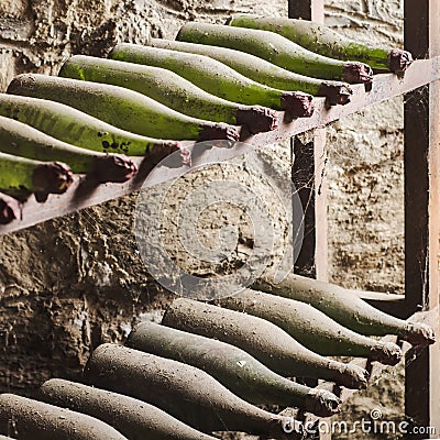 Old dusty wine bottles in cellar - square composition