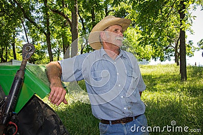 Old Farmer Stands by Tractor