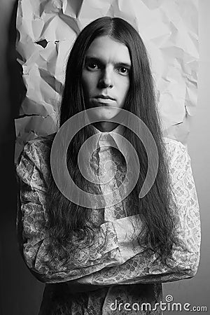 Old fashioned portrait of a long-haired boy over wrinkled paper