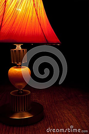 Old-fashioned table-lamp slightly lighten the darkness